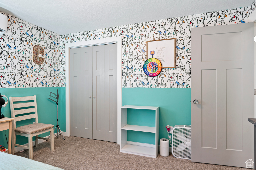 Bedroom featuring carpet floors, a textured ceiling, and a closet