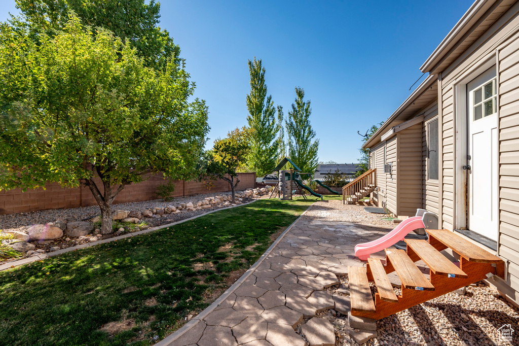 View of yard with a playground and a patio area