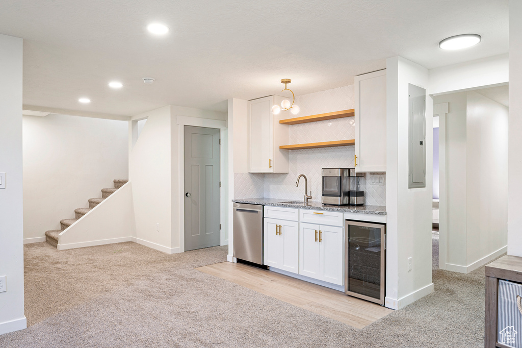 Kitchen with wine cooler, tasteful backsplash, sink, white cabinets, and stainless steel dishwasher