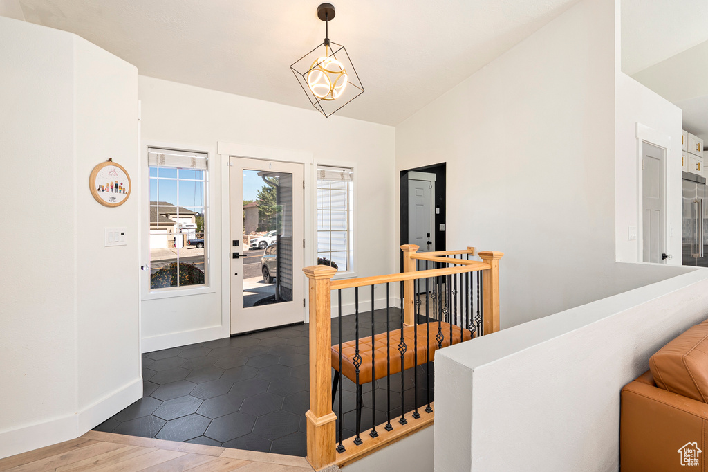 Entrance foyer featuring an inviting chandelier, lofted ceiling, and dark hardwood / wood-style floors