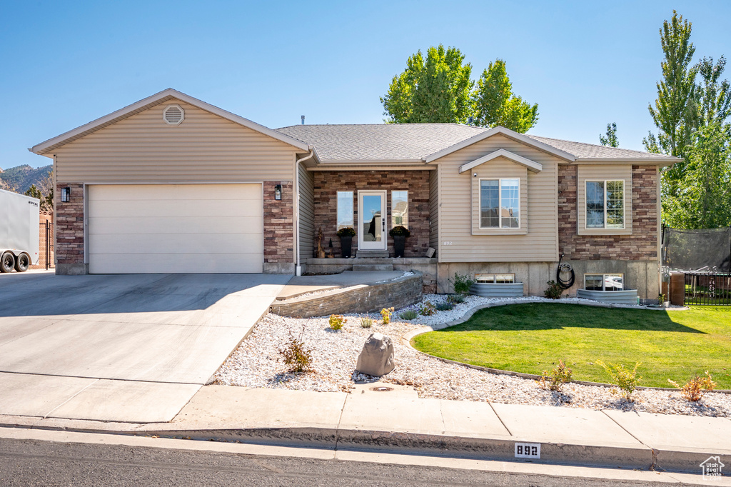 View of front facade featuring a front yard and a garage