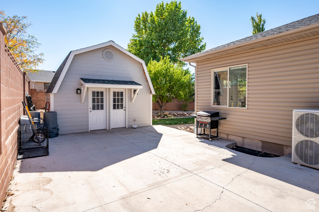 View of patio / terrace with ac unit, a grill, and an outbuilding