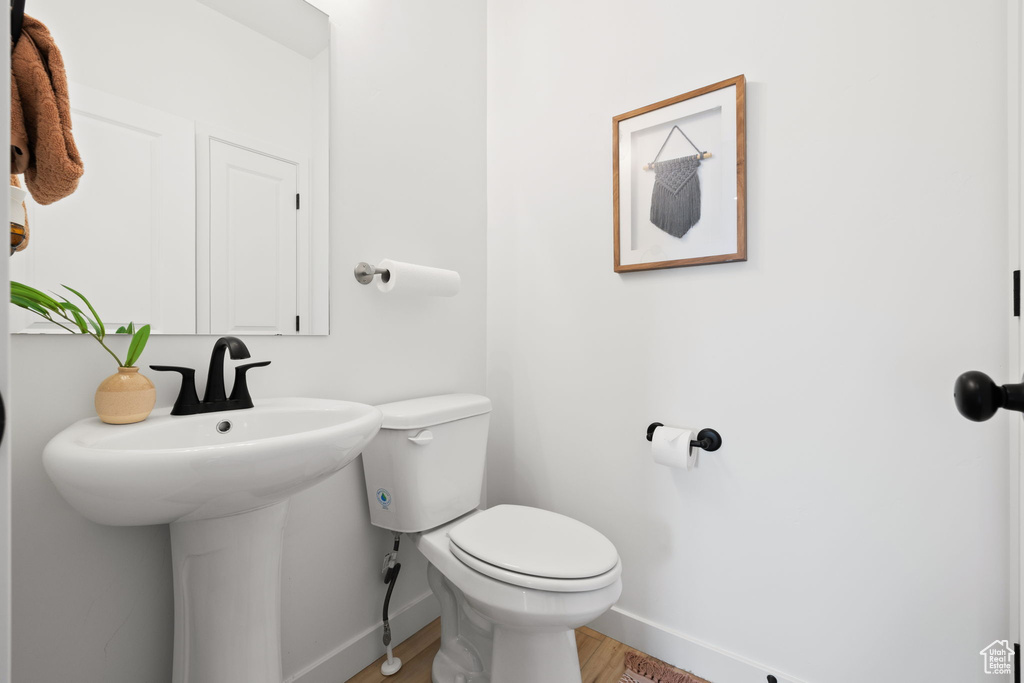 Bathroom featuring wood-type flooring and toilet