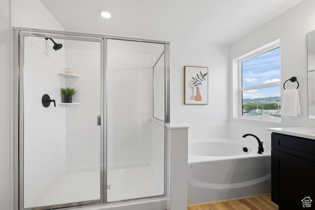 Bathroom featuring shower with separate bathtub, vanity, and wood-type flooring