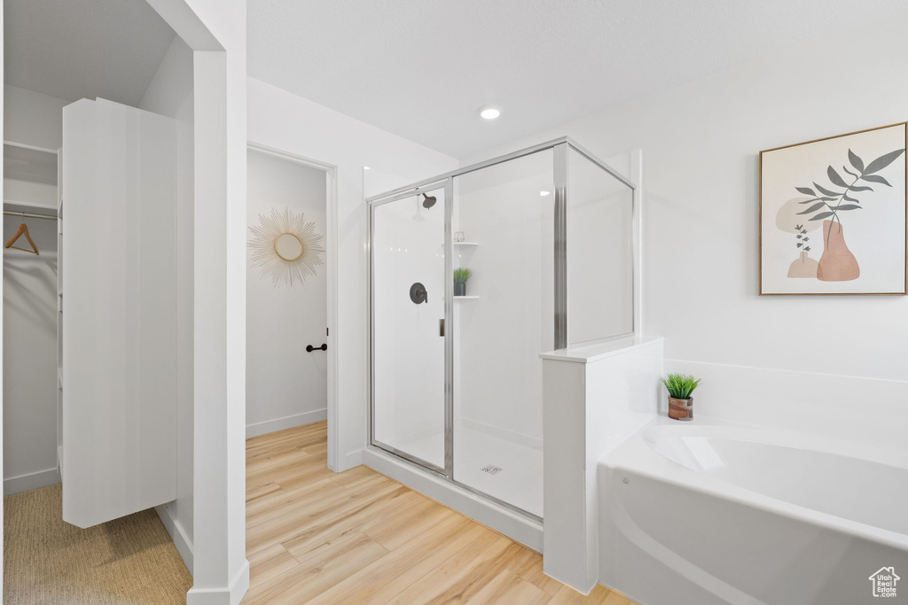 Bathroom featuring hardwood / wood-style flooring and separate shower and tub