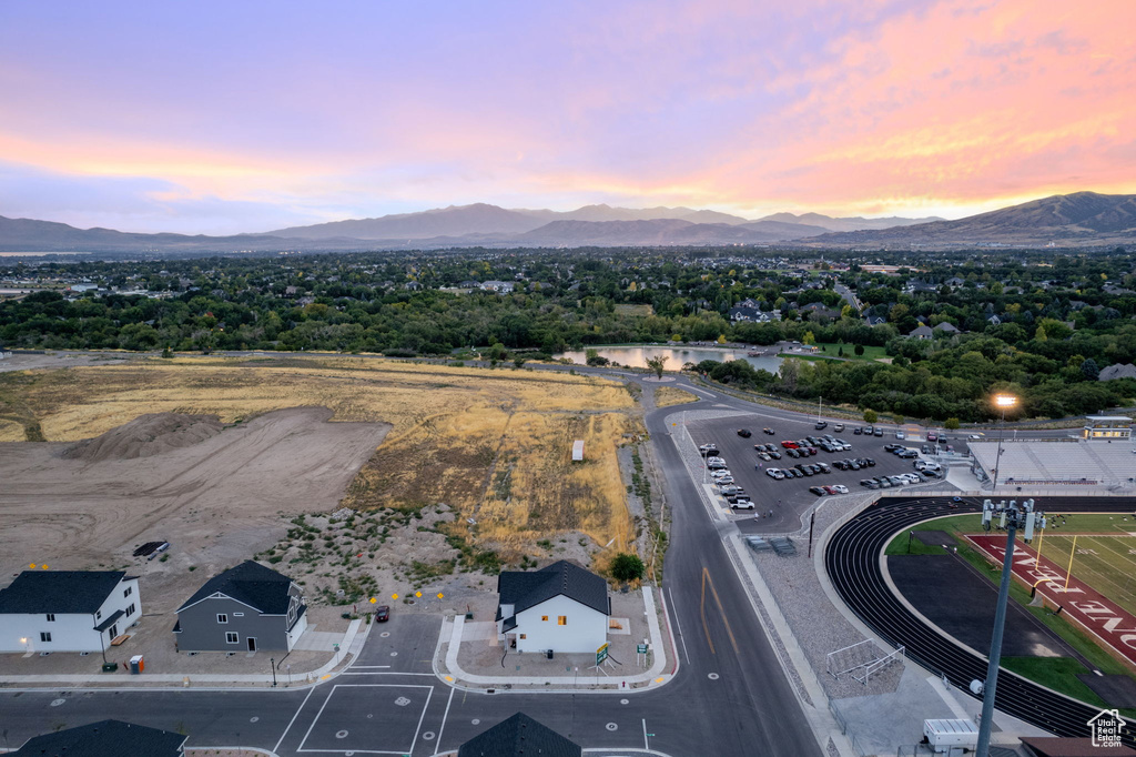 Aerial view at dusk featuring a water and mountain view