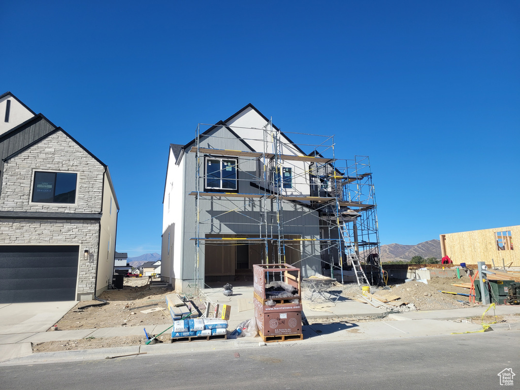 Property under construction featuring a mountain view and a garage