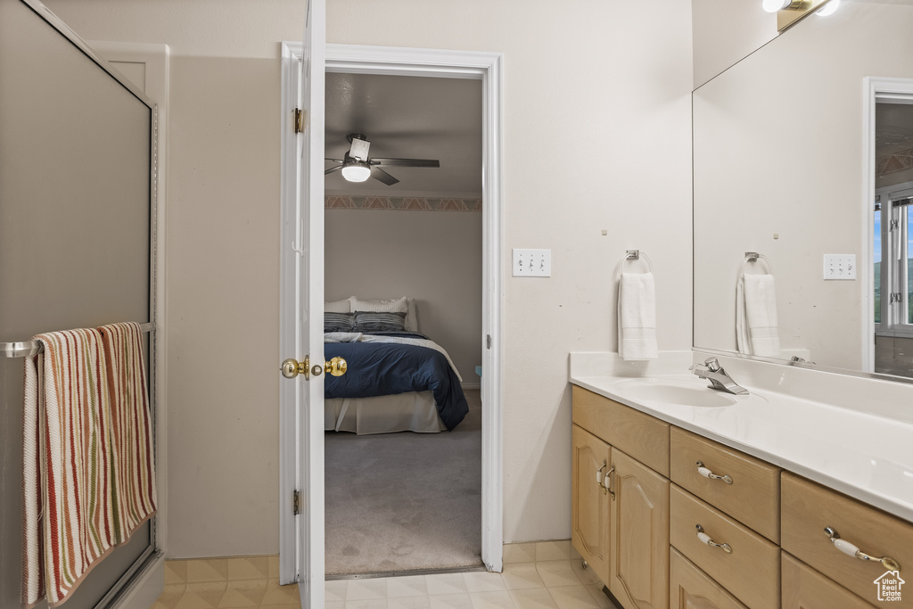 Bathroom with ceiling fan, vanity, and a shower with door