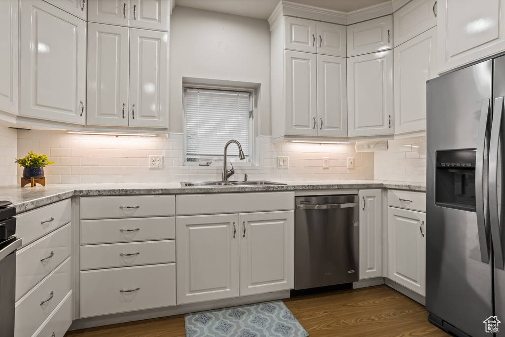 Kitchen featuring stainless steel appliances, white cabinetry, and sink