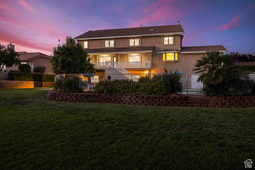 Back house at dusk with a yard