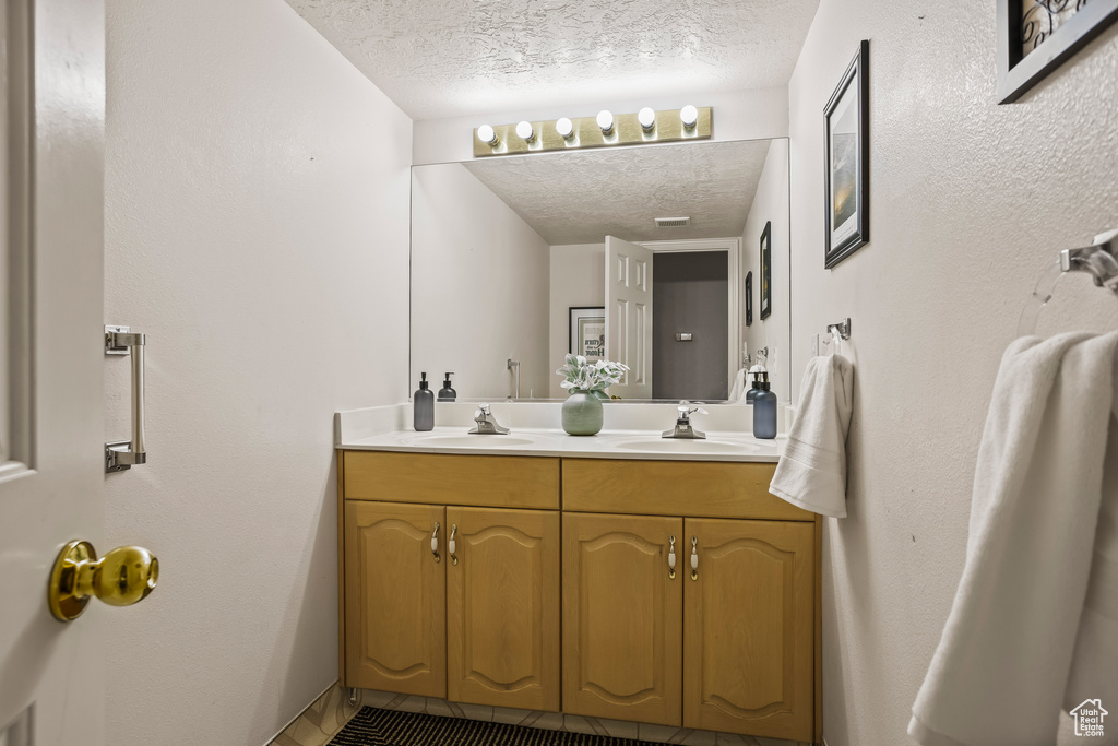 Bathroom with a textured ceiling and vanity