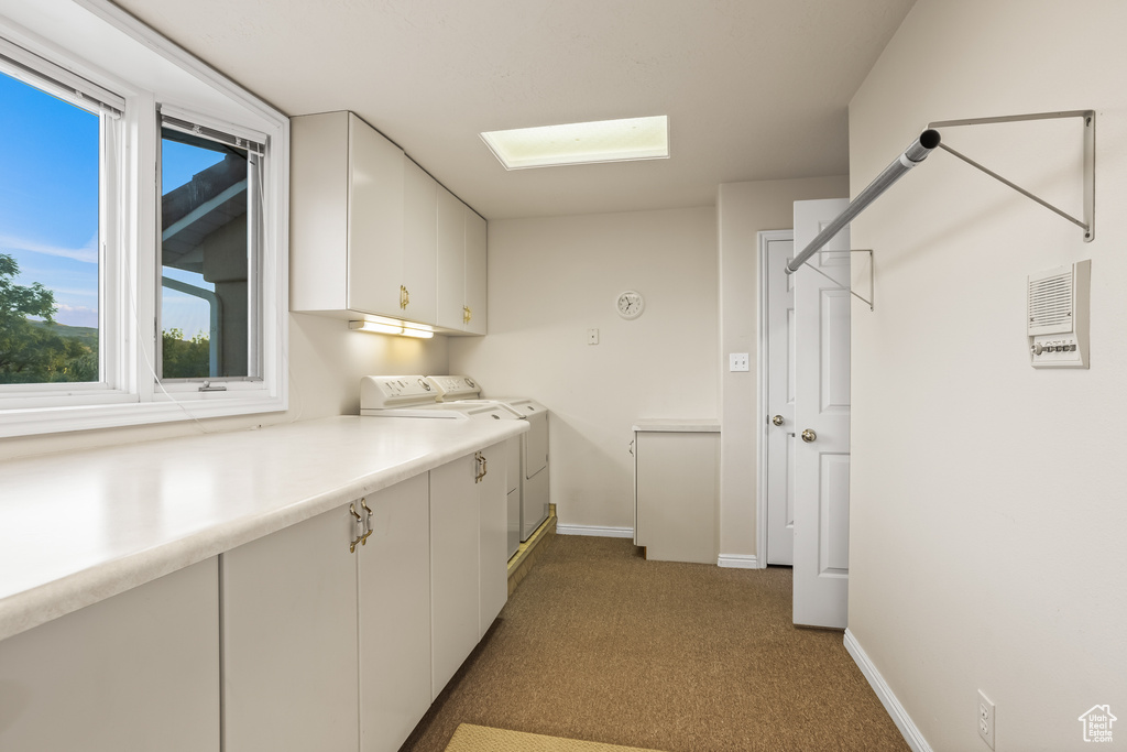 Washroom with light colored carpet and cabinets