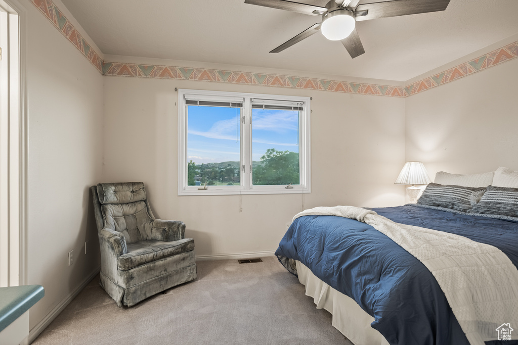 Carpeted bedroom featuring ceiling fan