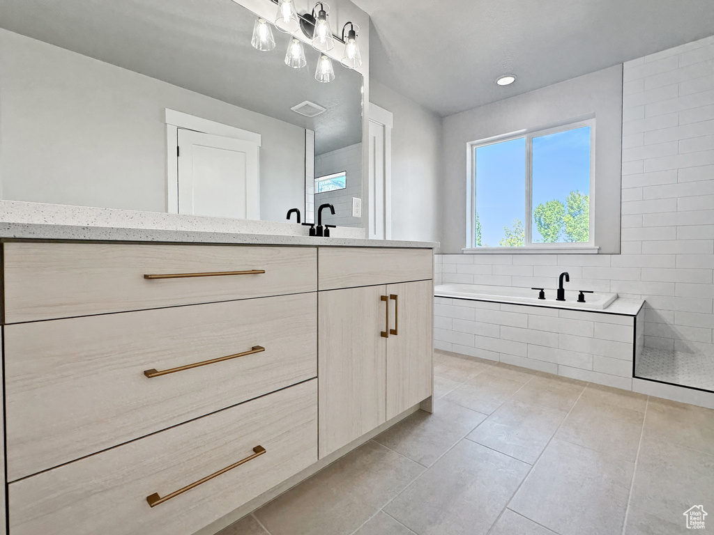 Bathroom featuring a bathtub, tile patterned floors, and vanity