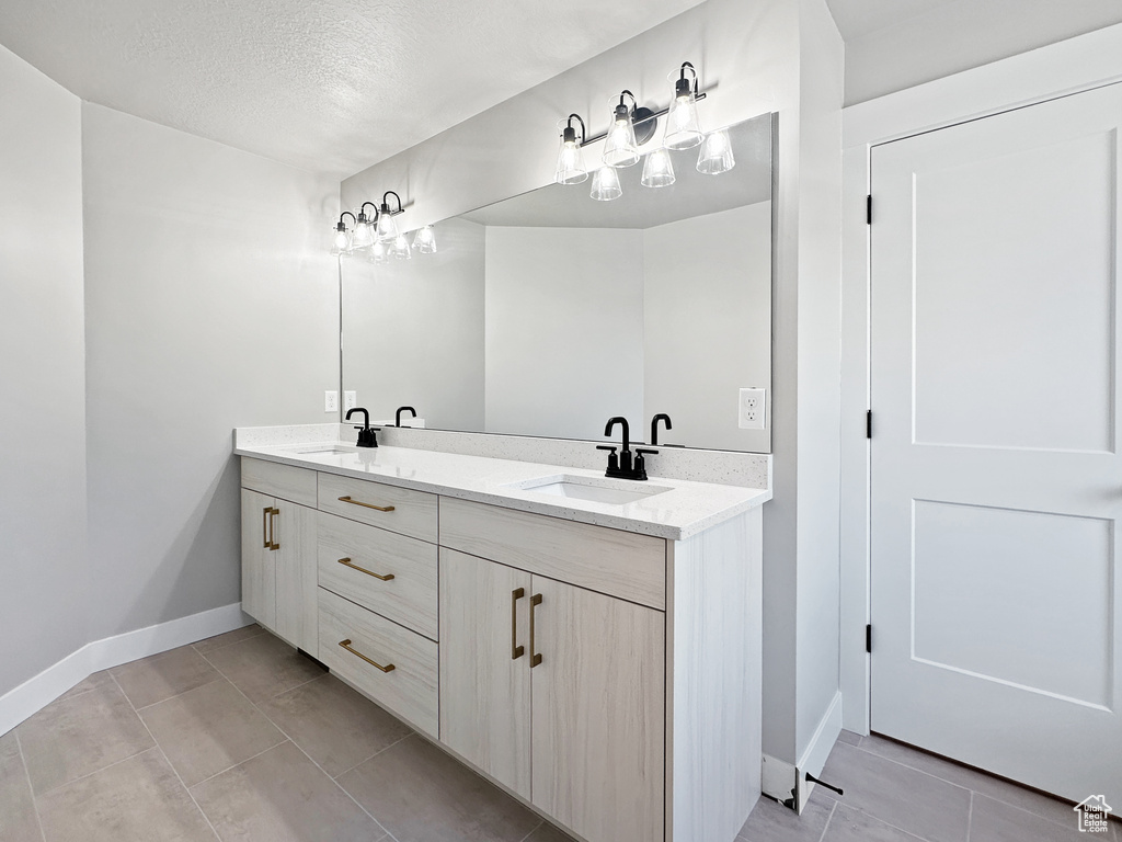 Bathroom featuring tile patterned floors, vanity, and a textured ceiling