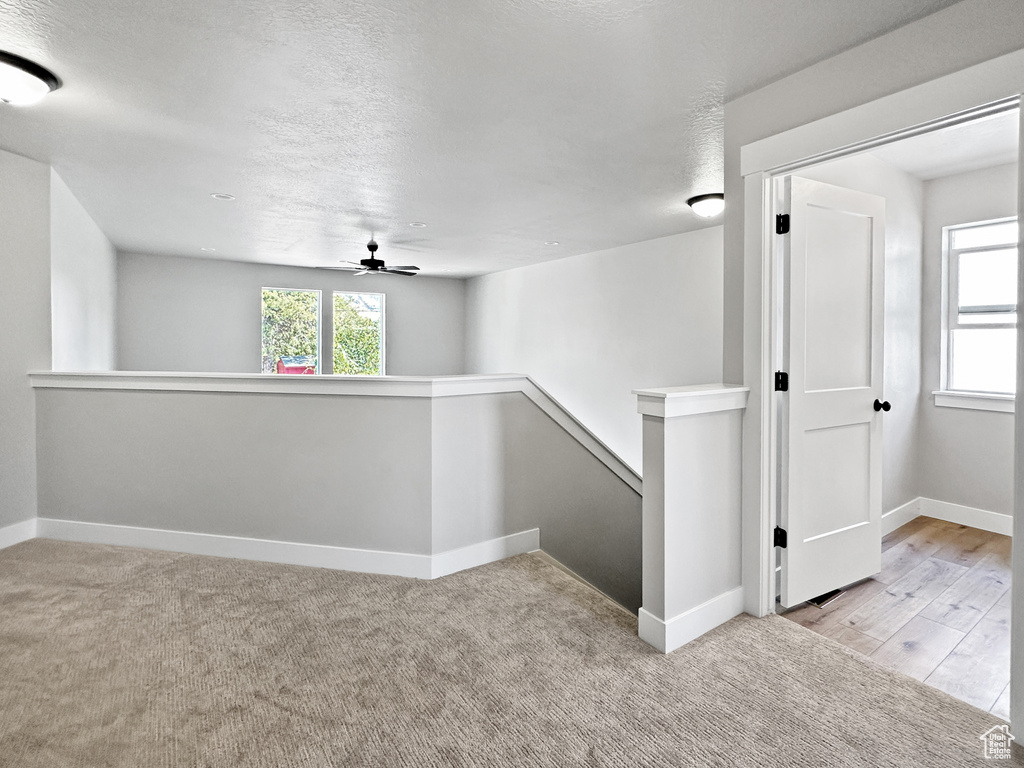 Hallway featuring light wood-type flooring and a textured ceiling