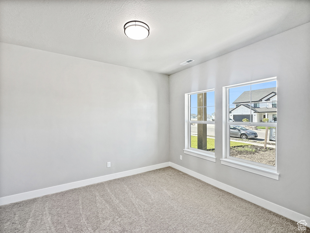 Carpeted empty room featuring a textured ceiling