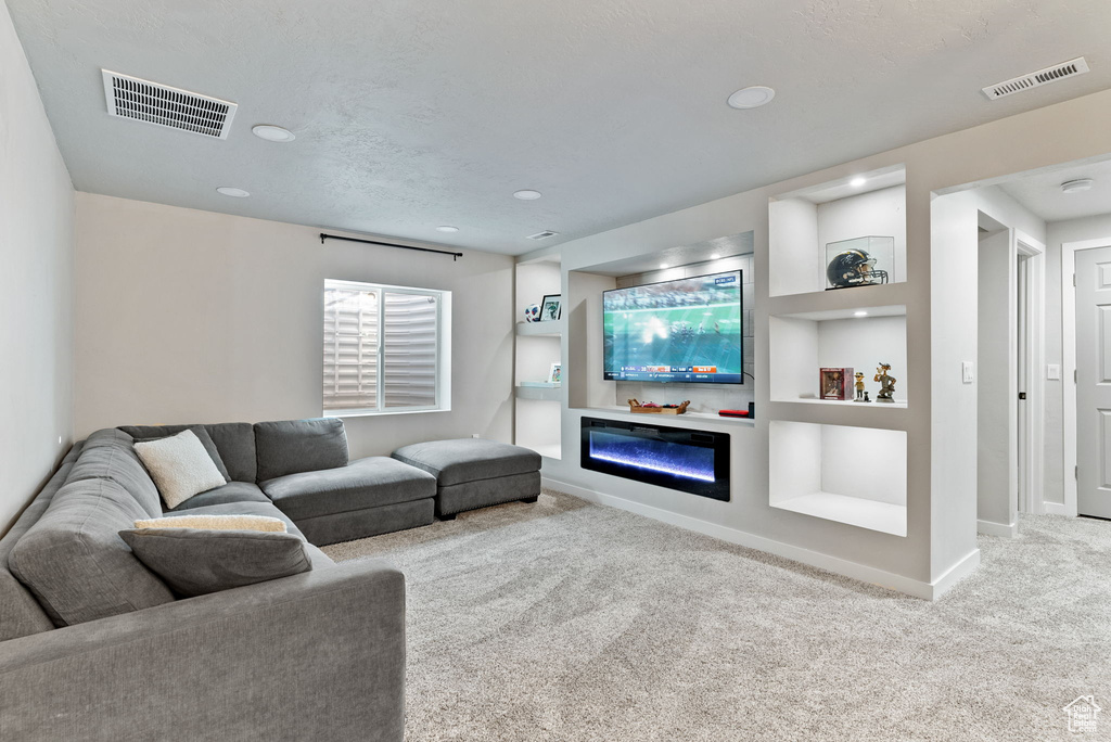 Living room with a textured ceiling and light colored carpet