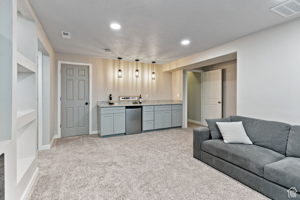 Carpeted living room featuring bar