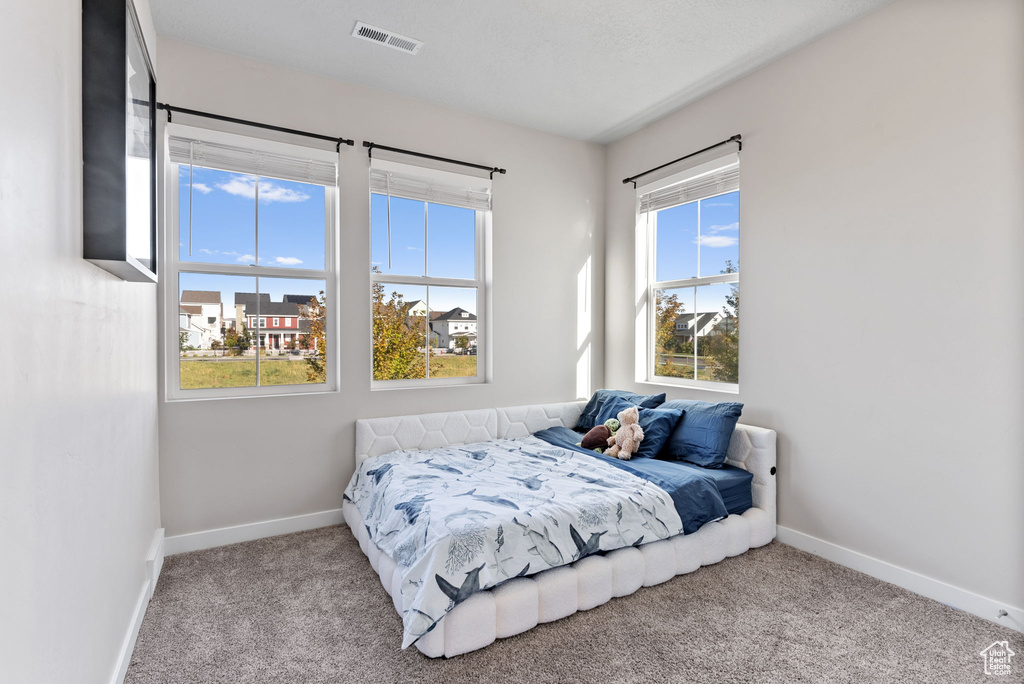 Bedroom featuring light carpet