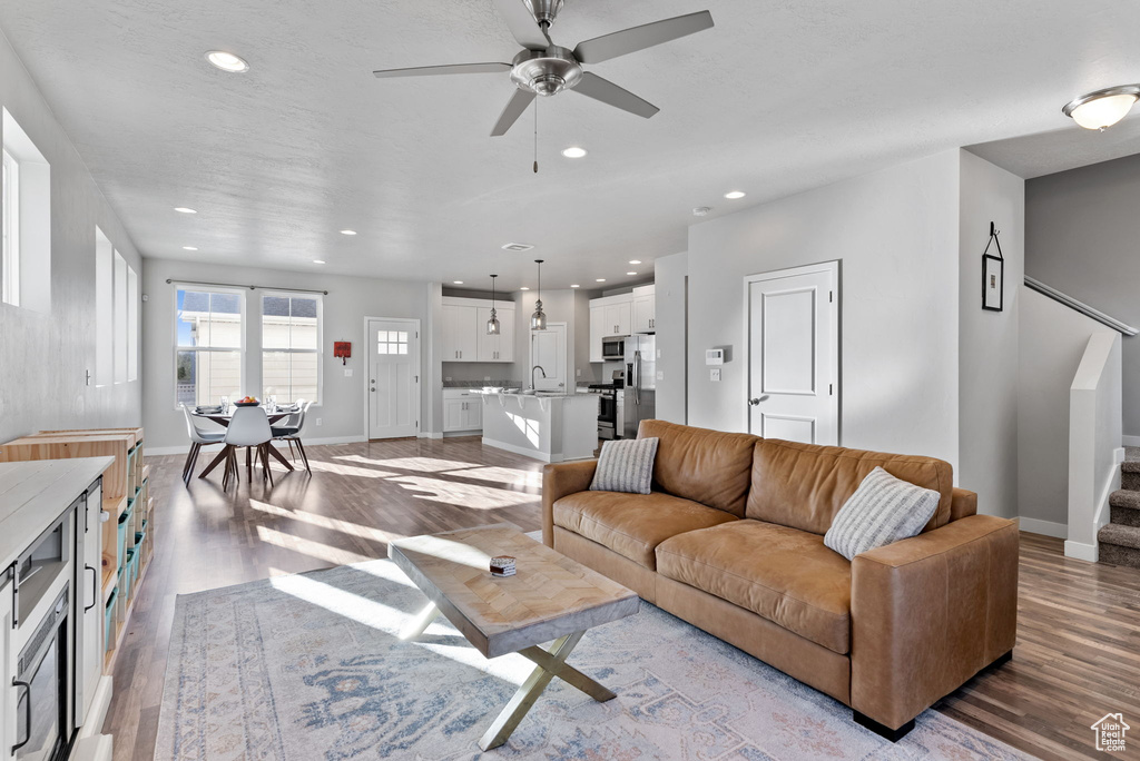 Living room featuring ceiling fan and light hardwood / wood-style floors