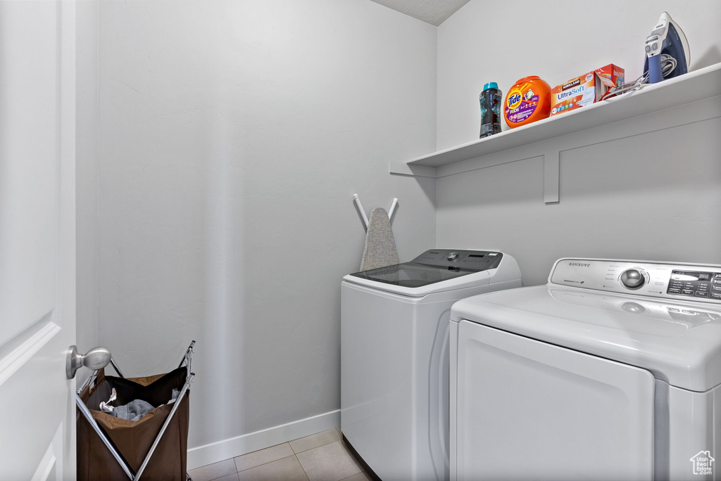 Laundry room featuring separate washer and dryer and light tile patterned floors