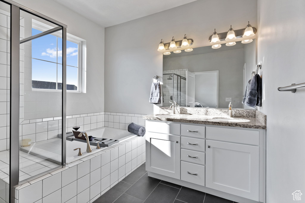 Bathroom with tile patterned flooring, vanity, and separate shower and tub