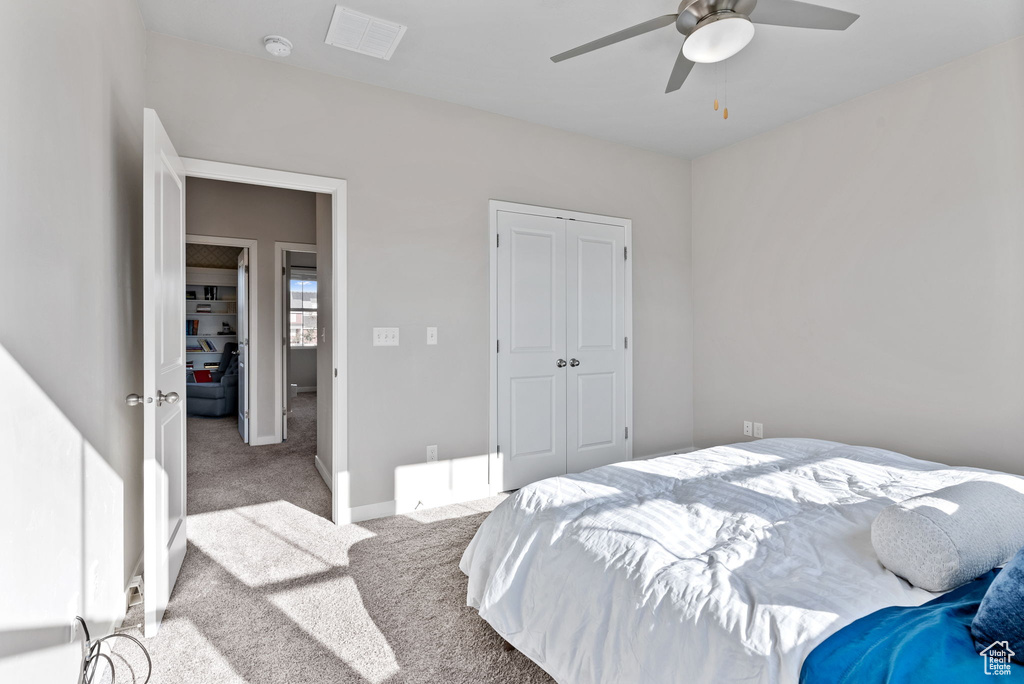 Carpeted bedroom with a closet and ceiling fan