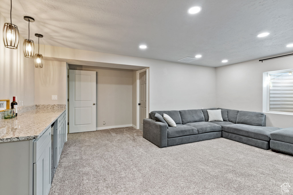 Living room featuring light colored carpet and a textured ceiling