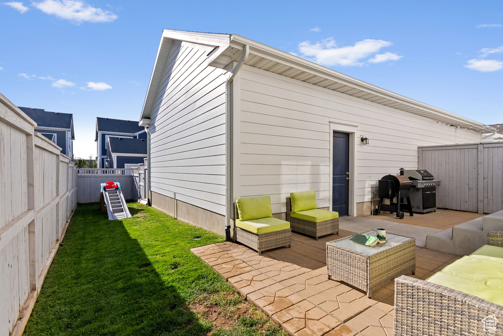 Rear view of house with outdoor lounge area, a patio area, and a yard