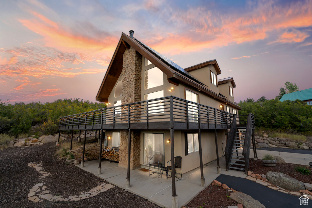 Back house at dusk featuring a patio area