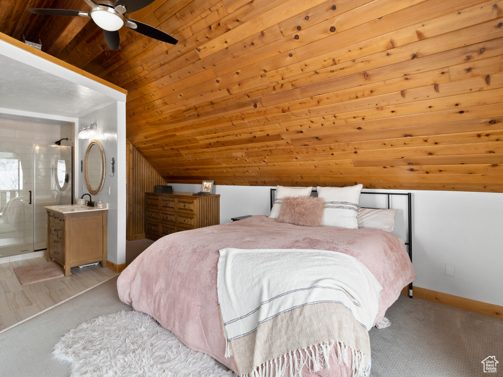 Bedroom with wood ceiling, vaulted ceiling, ceiling fan, ensuite bathroom, and sink