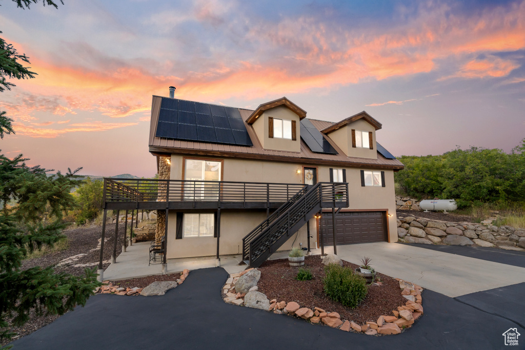 View of front of house with a garage and solar panels