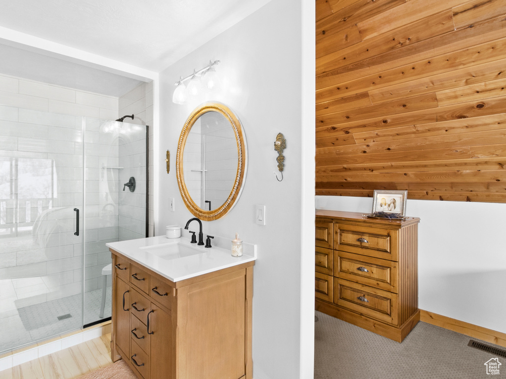 Bathroom with tile patterned flooring, vanity, and a shower with door