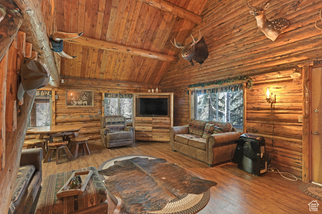 Living room featuring wood ceiling, beam ceiling, rustic walls, high vaulted ceiling, and hardwood / wood-style floors