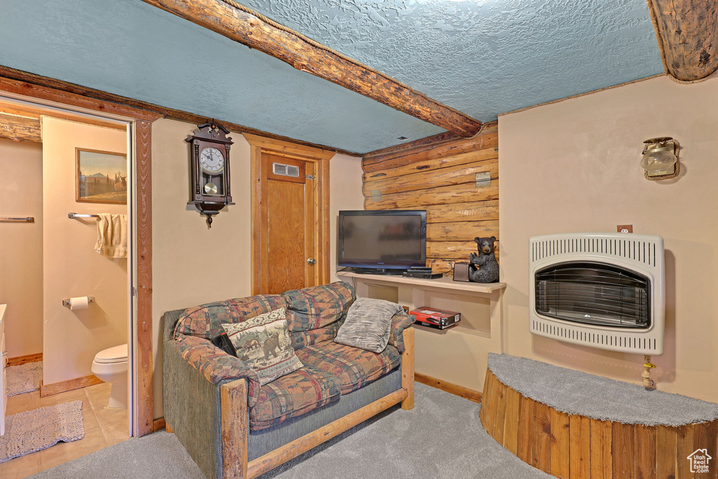 Tiled living room with heating unit, a textured ceiling, and wooden walls