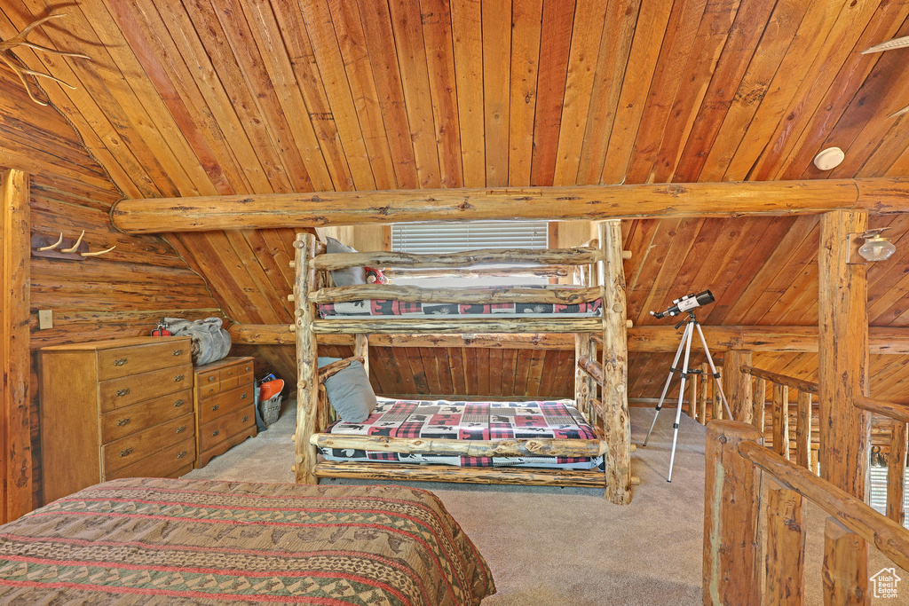 Carpeted bedroom with wood ceiling, wooden walls, and lofted ceiling