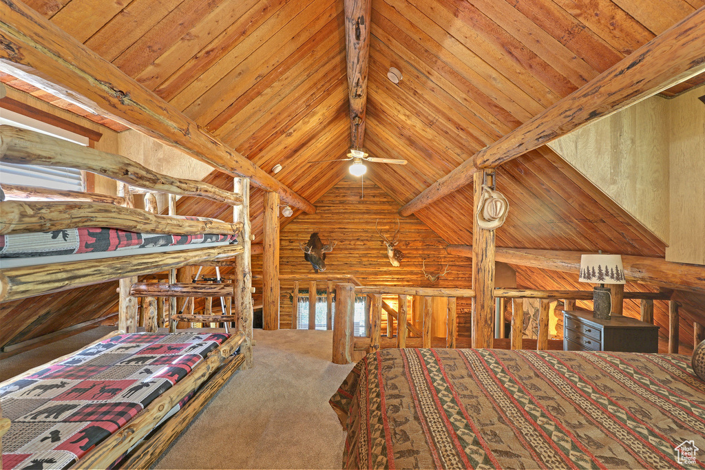 Unfurnished bedroom with wooden walls, beam ceiling, high vaulted ceiling, and wooden ceiling