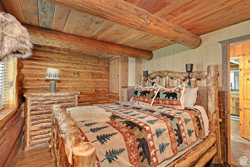 Bedroom with wooden ceiling, beamed ceiling, and hardwood / wood-style flooring