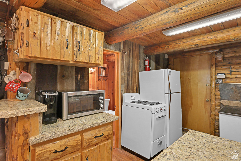 Kitchen featuring beamed ceiling, wood ceiling, wood walls, and white gas range