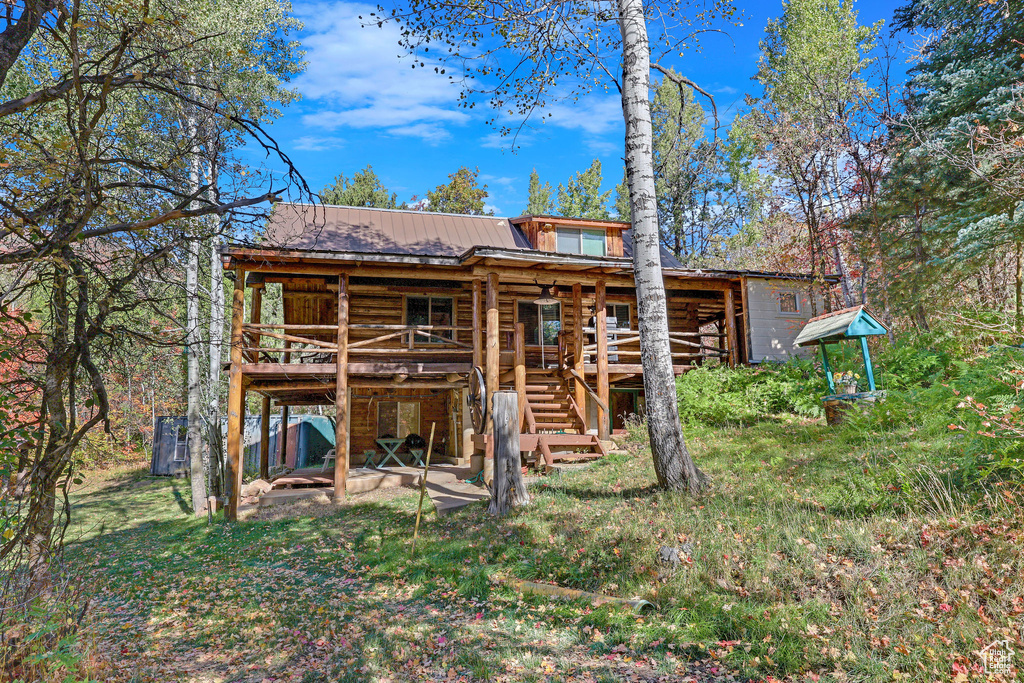 Rear view of house featuring a yard