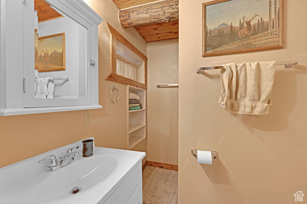 Bathroom with wood ceiling, vanity, and tile patterned floors