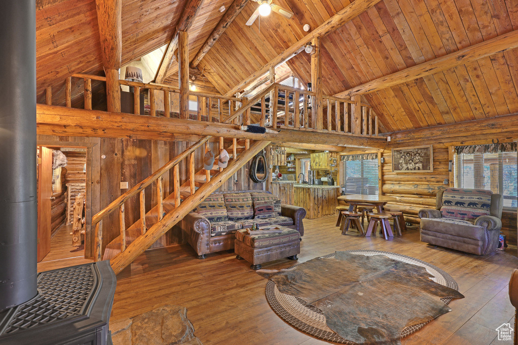 Living room with beam ceiling, high vaulted ceiling, and hardwood / wood-style flooring