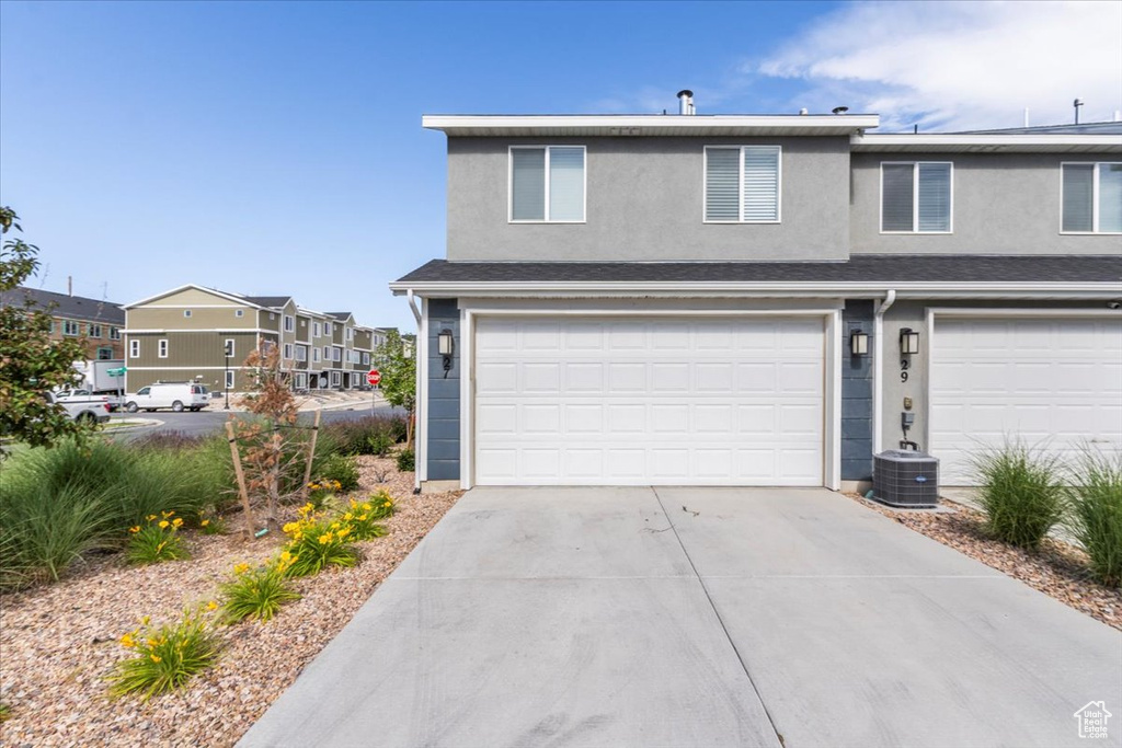 View of front of property with cooling unit and a garage