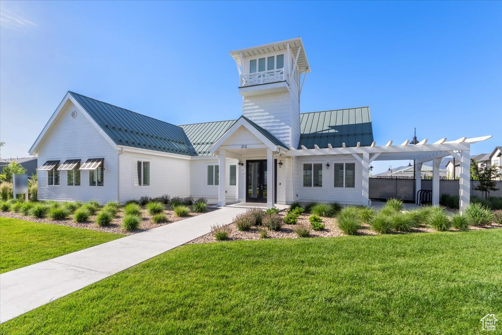 View of front of house featuring a pergola and a front lawn