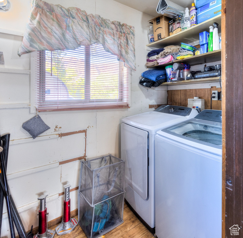 Laundry room with light wood-type flooring and separate washer and dryer