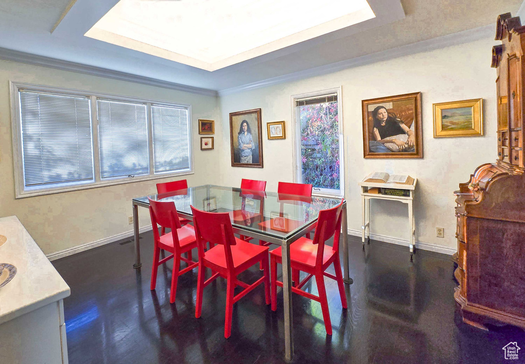 Dining area featuring a raised ceiling and crown molding