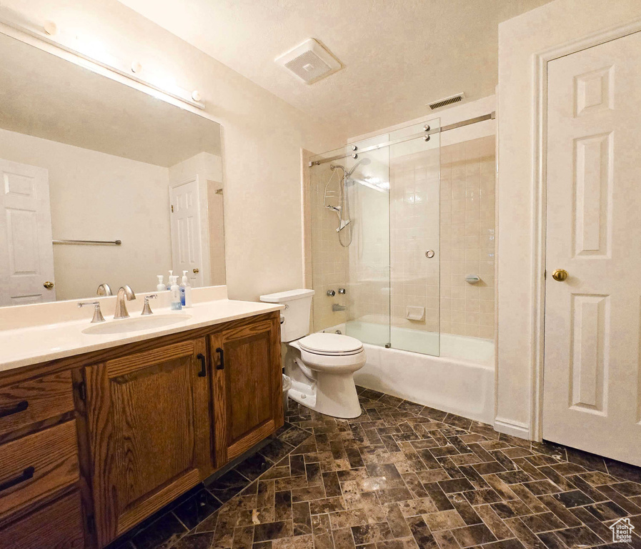 Full bathroom with vanity, toilet, and enclosed tub / shower combo