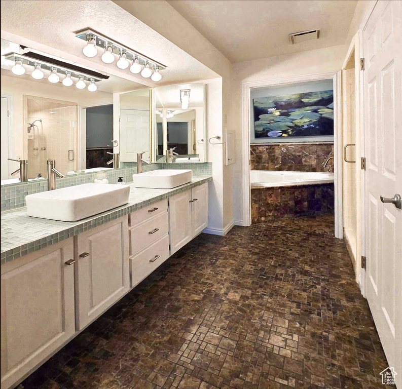 Bathroom with vanity and tiled bath