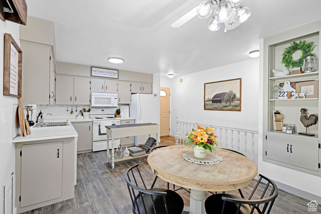 Dining space with sink and dark wood-type flooring